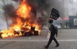 TOPSHOT - A Yellow Vest protester walk past a burning barricade during clashes with riot police forces on the Champs-Elysees in Paris on March 16, 2019, on the 18th consecutive Saturday of demonstrations called by the 'Yellow Vest' (gilets jaunes) movement. - Demonstrators hit French city streets again on March 16, for a 18th consecutive week of nationwide protest against the French President's policies and his top-down style of governing, high cost of living, government tax reforms and for more "social and economic justice." (Photo by Thomas SAMSON / AFP)